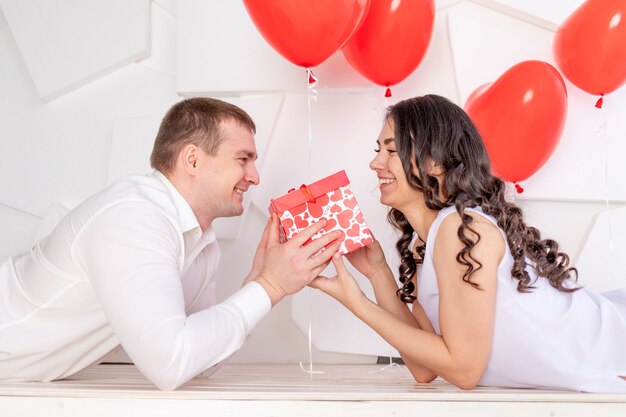 Valentinstag gibt ein Mann einem schönen Mädchen ein Geschenk