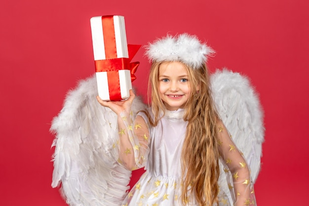Valentinstag glücklich lächelnd Amor Mädchen Kind Engel mit Geschenk kleiner Engel mit weißen Flügeln hält Geschenk p ...