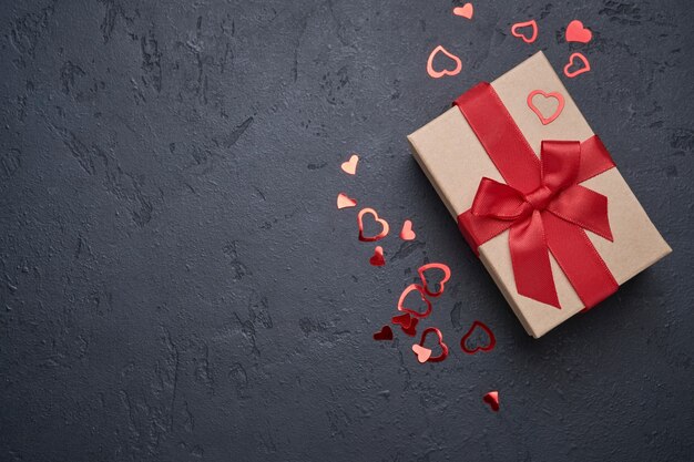 Valentinstag Grußkarte. Geschenkbox mit rotem Band und Herzfiguren