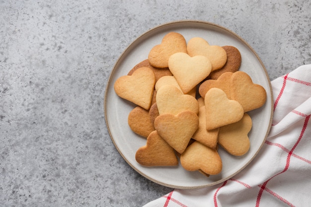 Valentinstag Grußkarte mit herzförmigen Keksen auf grauem Steintisch.