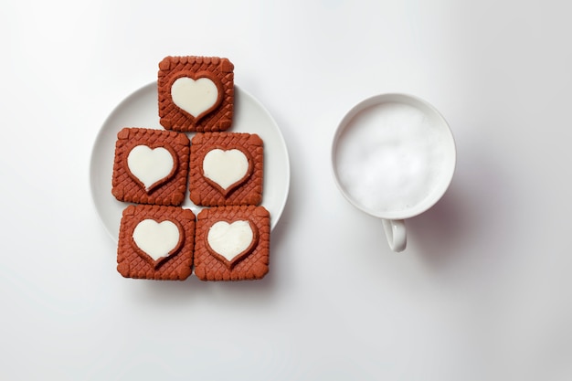 Valentinstag herzförmige Kekse und eine Tasse Cappuccino.