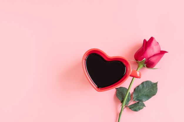 Valentinstag Hintergrund. Herzförmige Tasse schwarzen Kaffees und Rose auf Pastellrosa