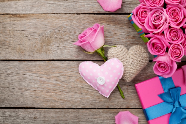 Valentinstag Hintergrund mit Geschenkbox voller rosa Rosen und handgemachten Spielzeugherzen