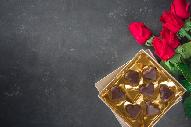 Valentinstag Hintergrund mit Pralinen Herzen und roten Rosen