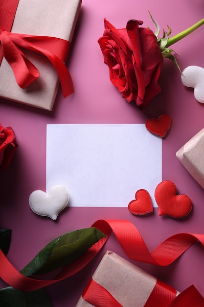 Valentinstag Hintergrundgrußkarte Liebessymbole, rote Dekoration mit Gläsern Herz Rosen Geschenke. Draufsicht mit Kopierraum und Text. Flache Lage