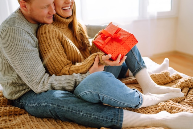 Valentinstag-Konzept Austausch von Geschenken Junges Paar zu Hause feiert den Valentinstag