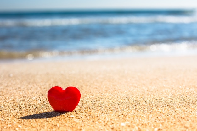 Valentinstag-Konzept Romantisches Liebessymbol des roten Herzens auf dem Sandstrand