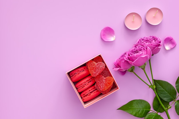 Valentinstag Konzept. Rosa Geschenkbox mit Marmelade und Makronen und einer schönen Rose