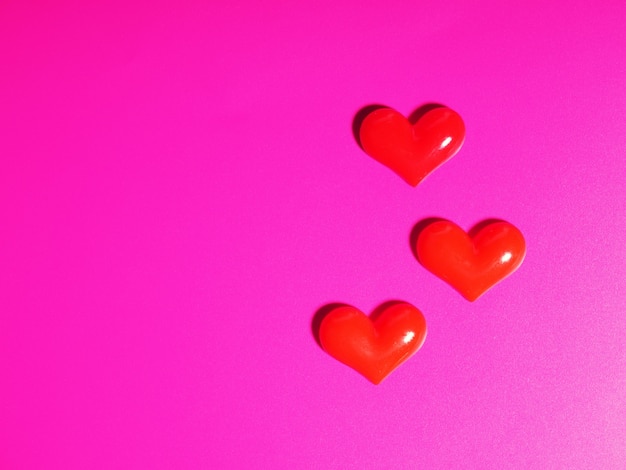 Valentinstag-Konzept, silbernes und rotes Herz auf rosa Hintergrund, Grußkarte.