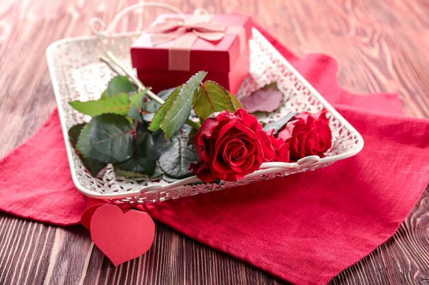 Valentinstag-Konzept Tablett mit schönen Rosen und Geschenkbox auf dem Tisch