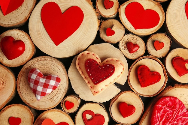 Valentinstag-Konzept Verschiedene bunte Herzen auf Holzstümpfen Hintergrund