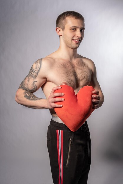 Valentinstag Mann mit Herz in der Hand eine junge gutaussehende aufgeblasene starke Fitness