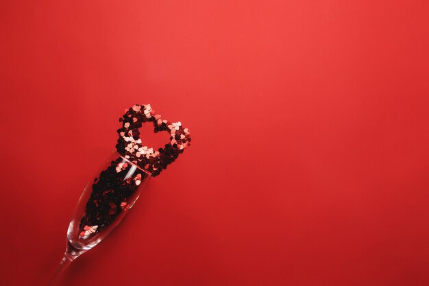 Valentinstag mit Weinglas, Herzglitter auf Rot