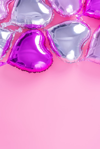 Valentinstag romantisches Designkonzept - Schöner echter Folienballon in Herzform einzeln auf hellrosa Hintergrund, Draufsicht, flache Lage, über der Fotografie.