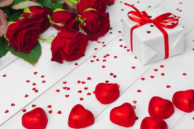 Valentinstag. Rote Rosen und Geschenkbox auf Holztisch