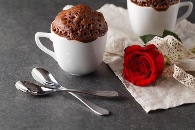 Valentinstag Tischdekoration mit Tassen, roten Herzen, Band und Rosen.