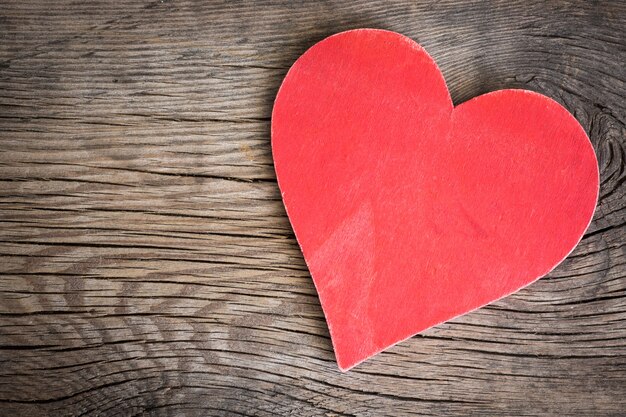 Valentinstag-Verzierung. Rote Herzen auf hölzernem Hintergrund. Grußkarte leer