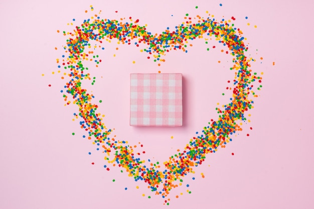 Valentinstag Zusammensetzung: Geschenkbox mit Schleife, Süßigkeiten und Süßigkeiten Herzen auf farbigem Hintergrund.