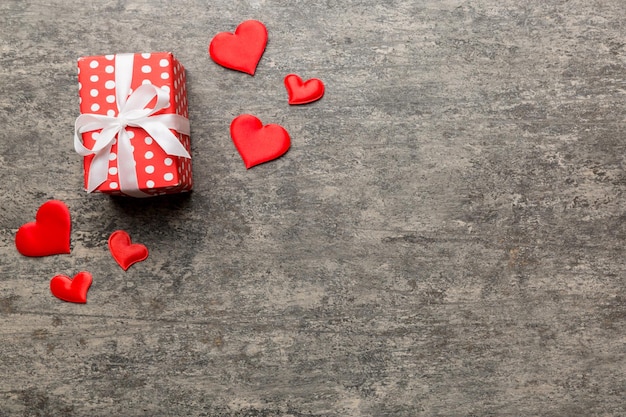 Valentinstag Zusammensetzung rote Geschenkbox mit Schleife und Herz Weihnachtsgeschenk Ansicht von oben Platz für Text Feiertags-Grußkarte