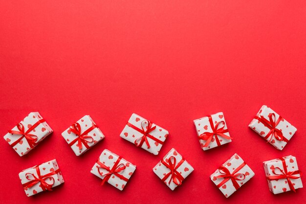 Valentinstag Zusammensetzung rote Geschenkbox mit Schleife und Herz Weihnachtsgeschenk Ansicht von oben Platz für Text Feiertags-Grußkarte