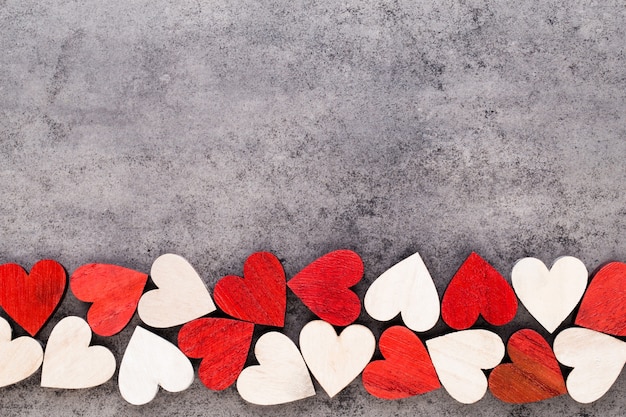Valentinstaghintergrund mit roten Herzen des weißen Endes auf hölzernem Hintergrund Auch im corel abgehobenen Betrag.