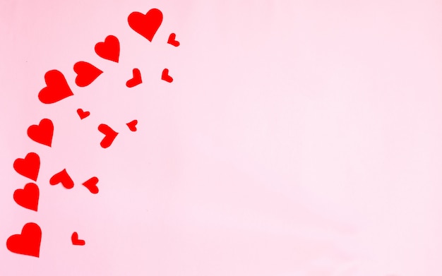 Valentinstaghintergrund mit roten Herzen und Zubehör auf rosa Hintergrund. Liebe formt Hintergrund. Flachgelegt, Draufsicht!
