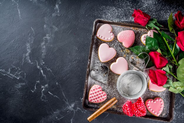 Valentinstagplätzchen auf Behälter voll des Bodens und der Rosen