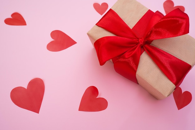 Valentinstagsgeschenk auf rosa Hintergrund mit roten hausgemachten Herzen Valentinstag Liebeskonzept