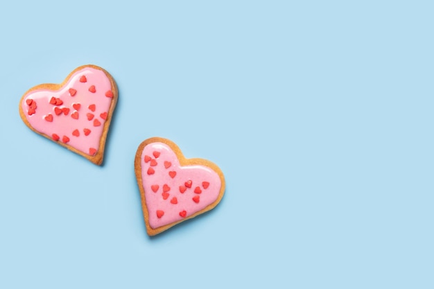 Valentinstagsgrußkarte mit glasförmigen herzförmigen Kekse auf blauem Hintergrund