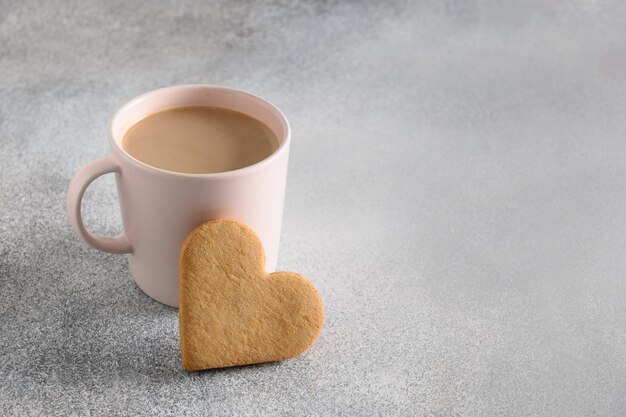 Valentinstagskaffee und herzförmiger Keks zum Frühstück.