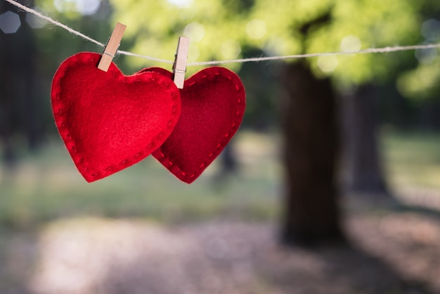 Valentinstagskarte. Zwei rote Herzen auf einem unscharfen Hintergrund im Park