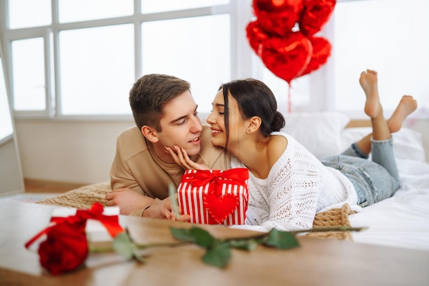 Valentinstagskonzept Liebhaber geben sich gegenseitig Geschenke Paar feiert Valentinstag zu Hause