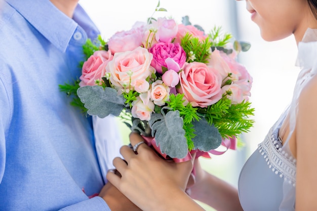 Valentinstagskonzept, Nahaufnahme des asiatischen jungen glücklichen süßen Paares, das Strauß der roten und rosa Rosen nach dem Mittagessen in einem Restaurant hält