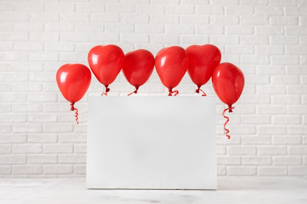 Valentinstagzusammensetzung mit roten Ballons auf Weiß