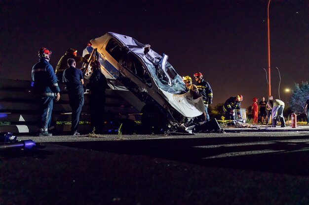 Valientes bomberos intentando liberar al hombre del coche accidentado.