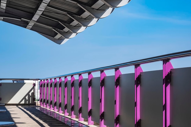 Valla de acero de seguridad con techo en la plataforma vacía de la estación de tren del cielo en la ciudad