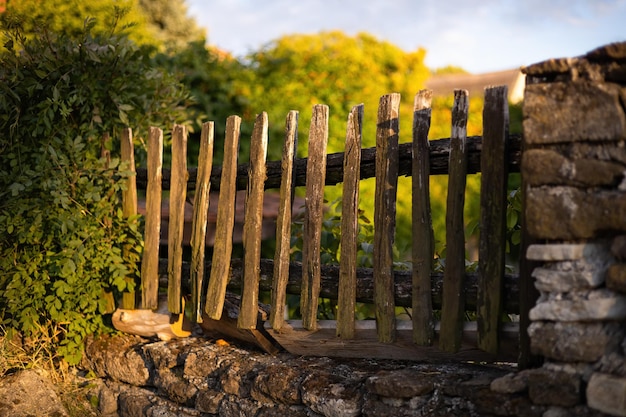 Valla de estacas de madera vieja construida en una pared de piedras