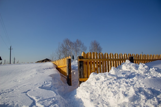 Valla de madera en la nieve. Fondo de nieve.