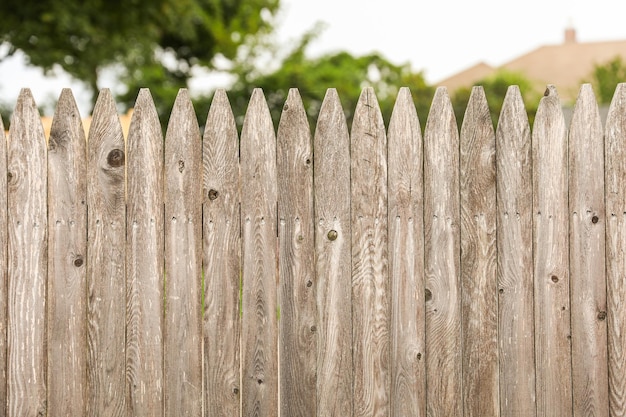 valla de madera de pie, su textura desgastada y su construcción robusta simbolizan tanto la seguridad como