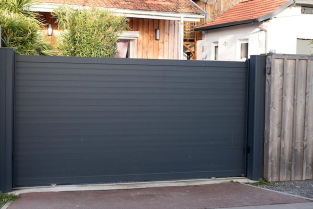 Valla de portal de metal gris grande de acero de puerta corredera en la calle de la casa moderna