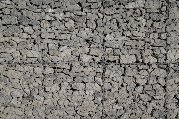 Valla con textura de piedra hecha de malla y piedras pared de fondo fachada horizontal