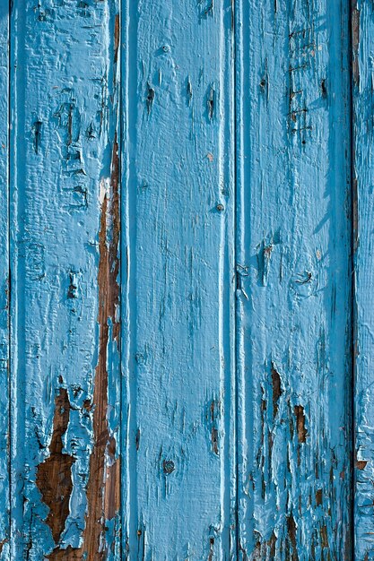 Valla de viejas placas azules con pintura vieja agrietada dispuestas verticalmente