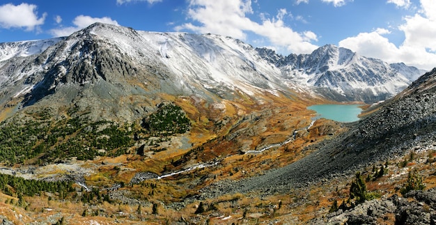 Valle de montaña con un lago picos nevados otoño