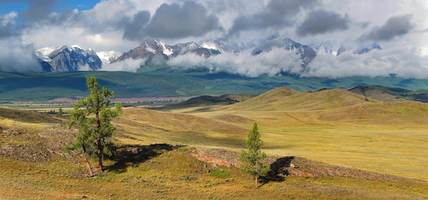 Valle de montaña y picos en las nubes.