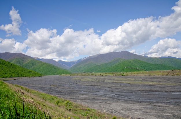 Valle no rico río de montaña entre verdes colinas. Cáucaso, Georgia