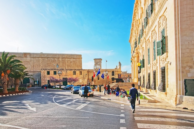 Valletta, Malta - 1 de abril de 2014: Pessoas no edifício Auberge de Castille na Merchant Street, no centro da cidade velha de Valletta, Malta