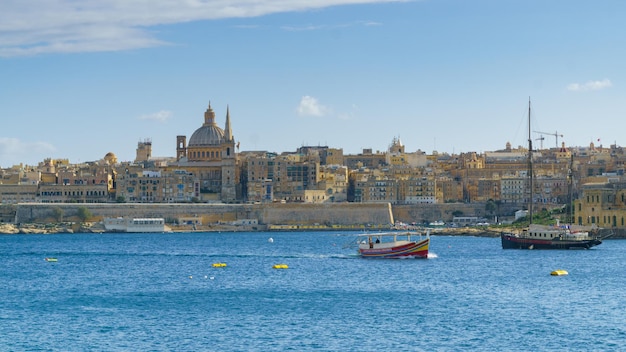 Valletta, Malta - 27. November 2017 Valletta morgendliche Skyline mit der Basilika Unserer Lieben Frau vom Berg Karmel, Mittelmeer mit antikem Kreuzfahrtschiff von Sliema, Malta aus gesehen.