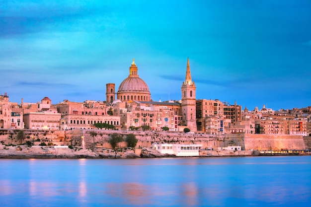 Valletta Skyline bei schönem Sonnenuntergang von Sliema mit Kirchen Unserer Lieben Frau vom Berg Carmel und St. Paul's Anglican Pro-Cathedral, Valletta, Hauptstadt von Malta