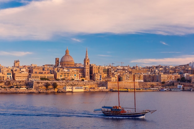 Valletta Skyline com navio no belo pôr do sol de Sliema com as igrejas de Nossa Senhora do Monte Carmelo e a Pró-Catedral Anglicana de São Paulo, Valletta, capital de Malta