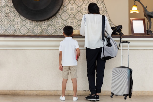 Valor da família mãe e filho, check-in no hotel com mala